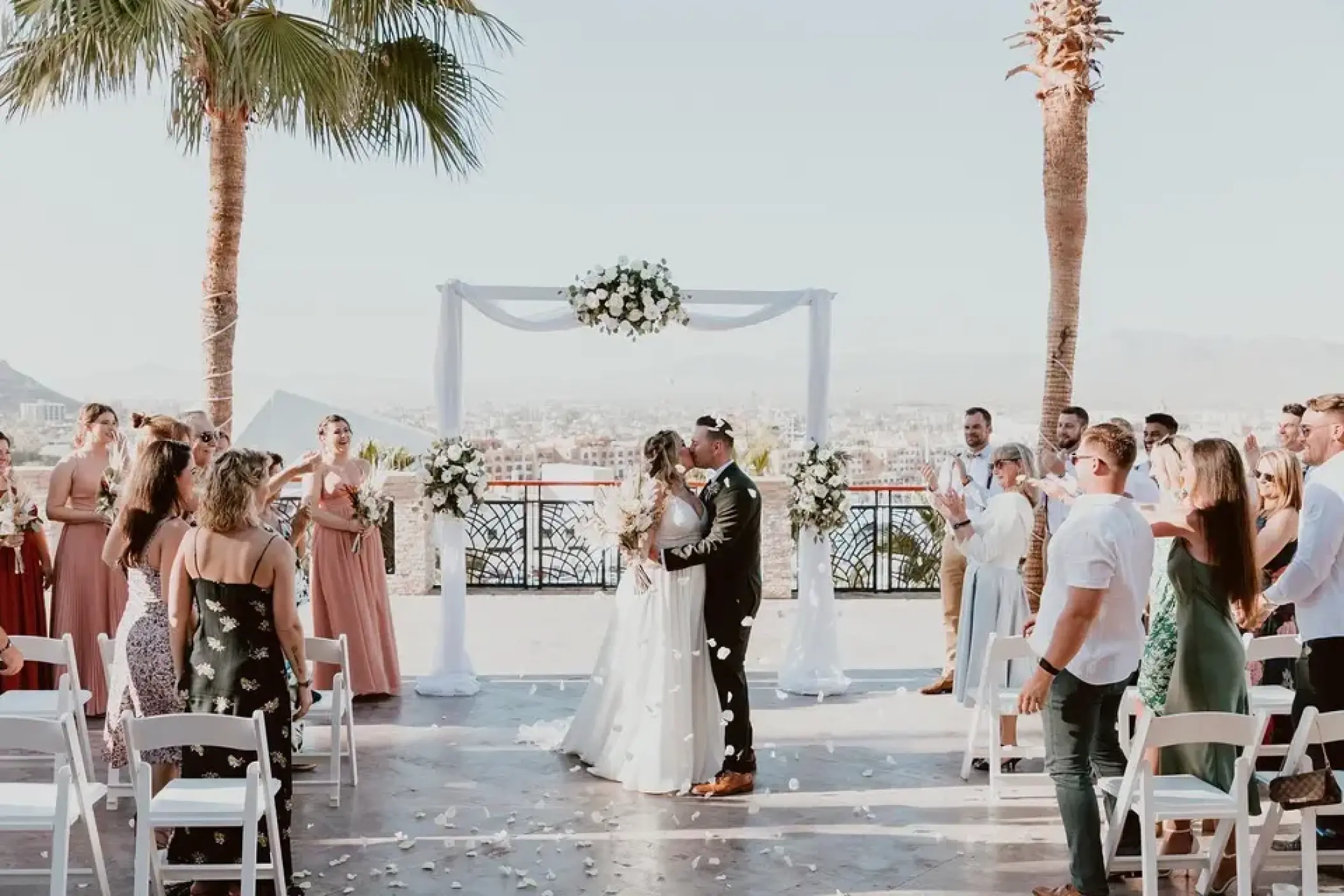 Bride and groom kissing at a terrace wedding ceremony at Sandos Finisterra, Cabo San Lucas