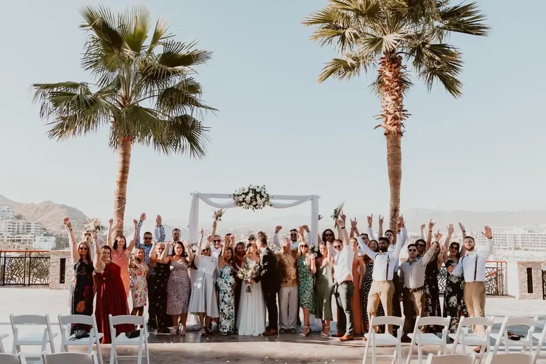 Wedding party cheering at a terrace ceremony in Sandos Finisterra, Cabo San Lucas