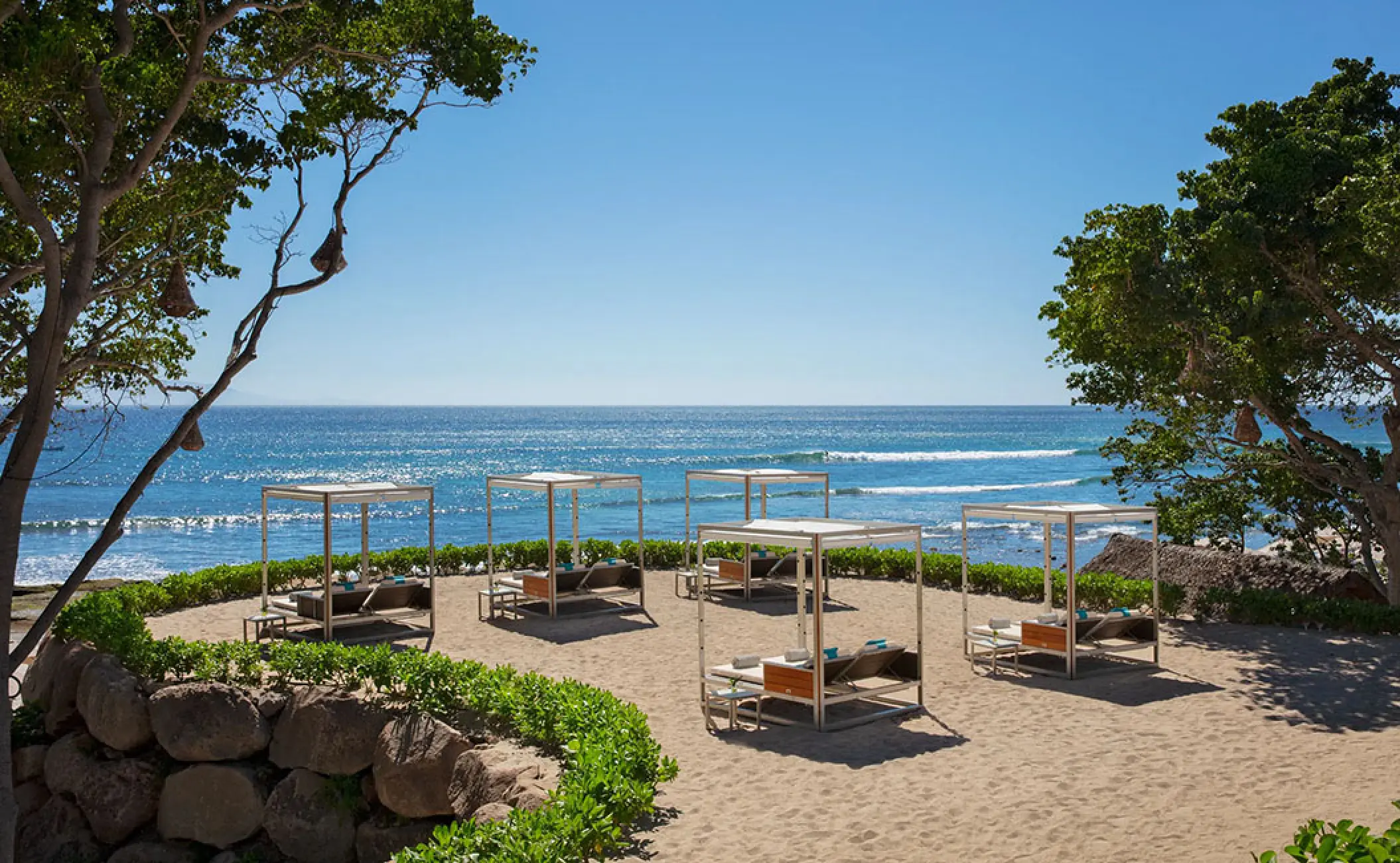 Beachfront lounge terrace with shaded daybeds overlooking the ocean at Secrets Bahia Mita, Puerto Vallarta