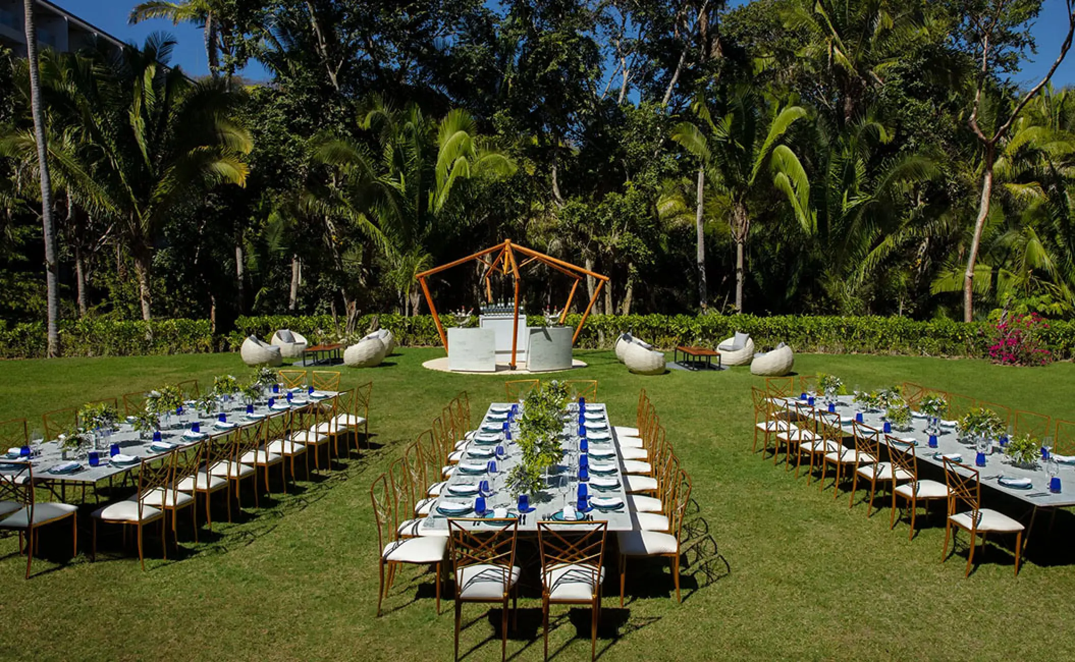 Garden wedding reception with long banquet tables and gold chairs at Secrets Bahia Mita, Puerto Vallarta