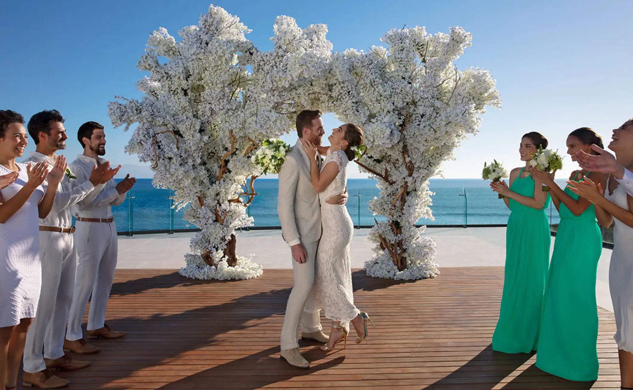 Outdoor wedding ceremony under a white floral arch at Secrets Bahia Mita, Puerto Vallarta