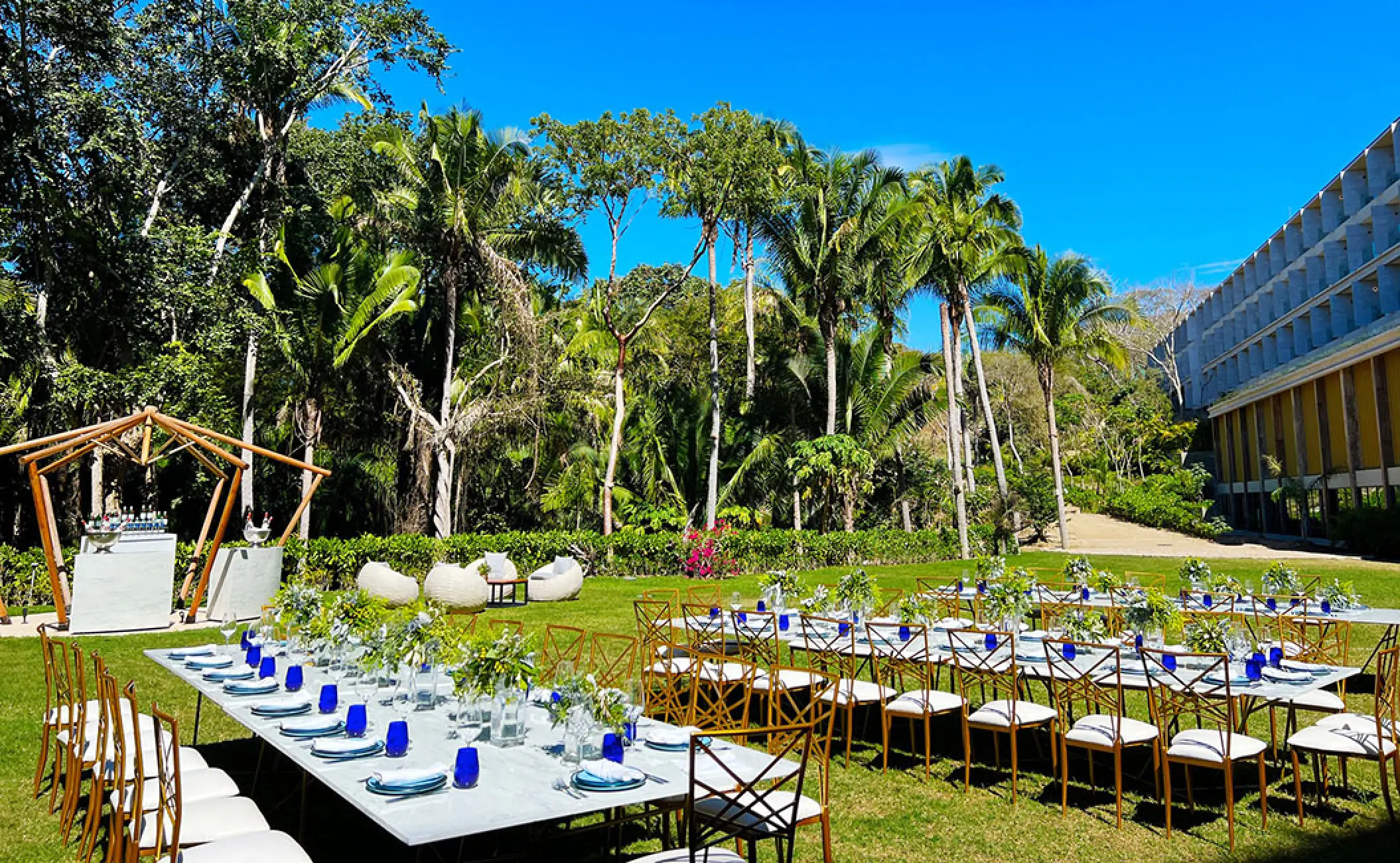 Outdoor garden wedding reception with long tables and blue glassware at Secrets Bahia Mita, Puerto Vallarta