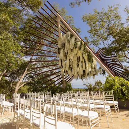 The Nest wedding ceremony venue with white chairs and floral installation at Secrets Bahia Mita, Puerto Vallarta