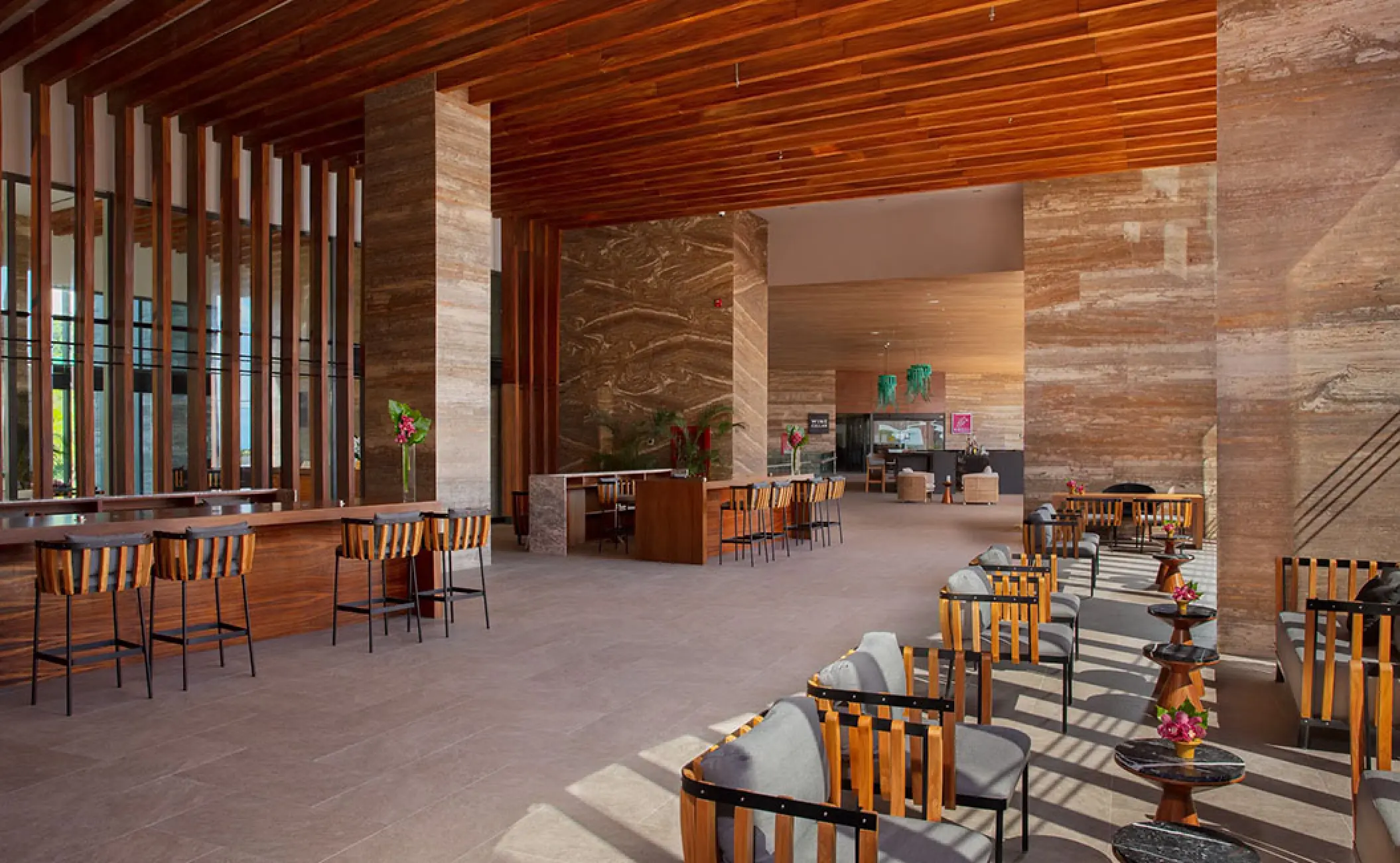 Modern open-air lobby with stone pillars and wooden accents at Secrets Bahia Mita, Puerto Vallarta