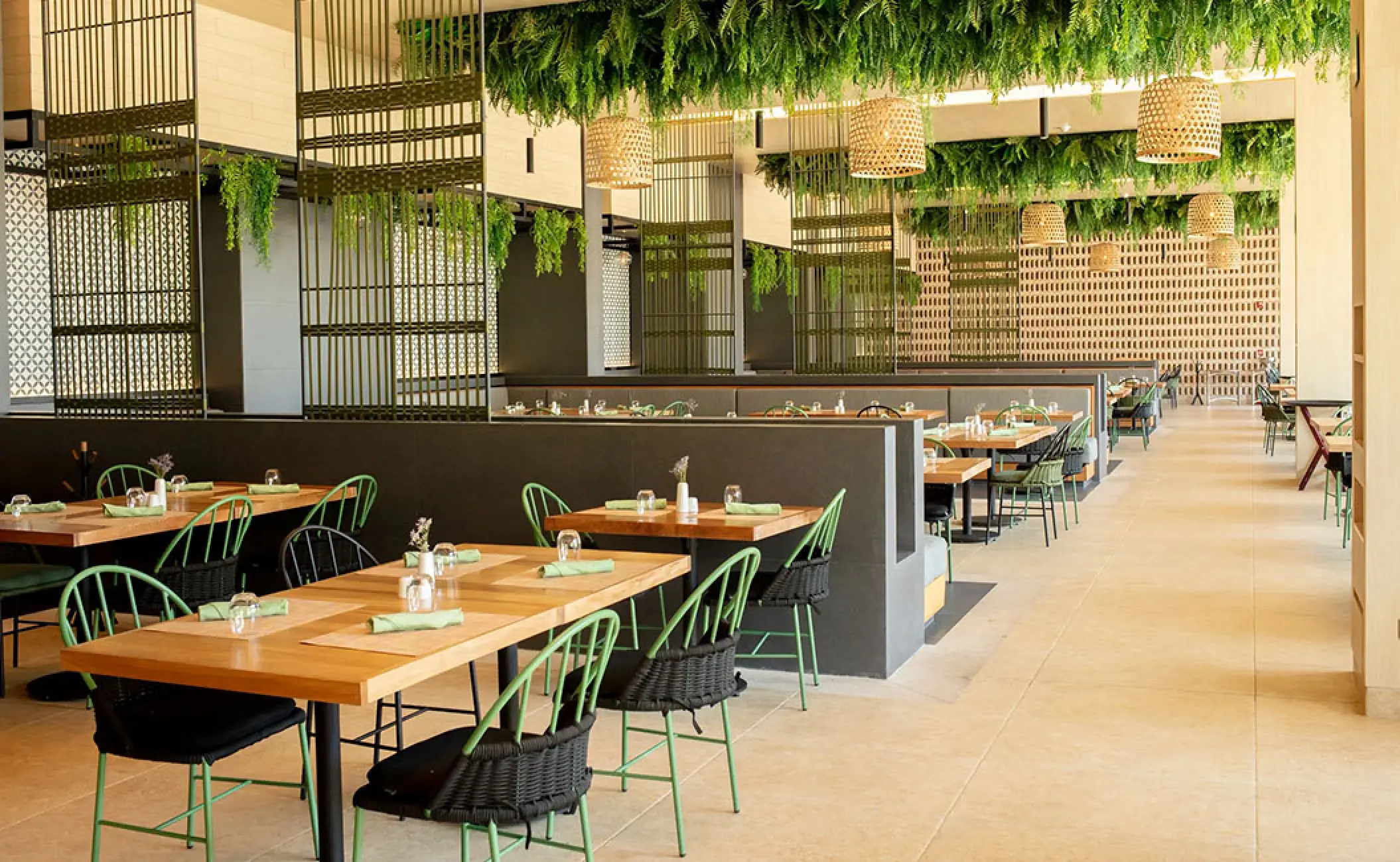 World Cafe restaurant dining room with green accents and hanging plants at Secrets Bahia Mita, Puerto Vallarta