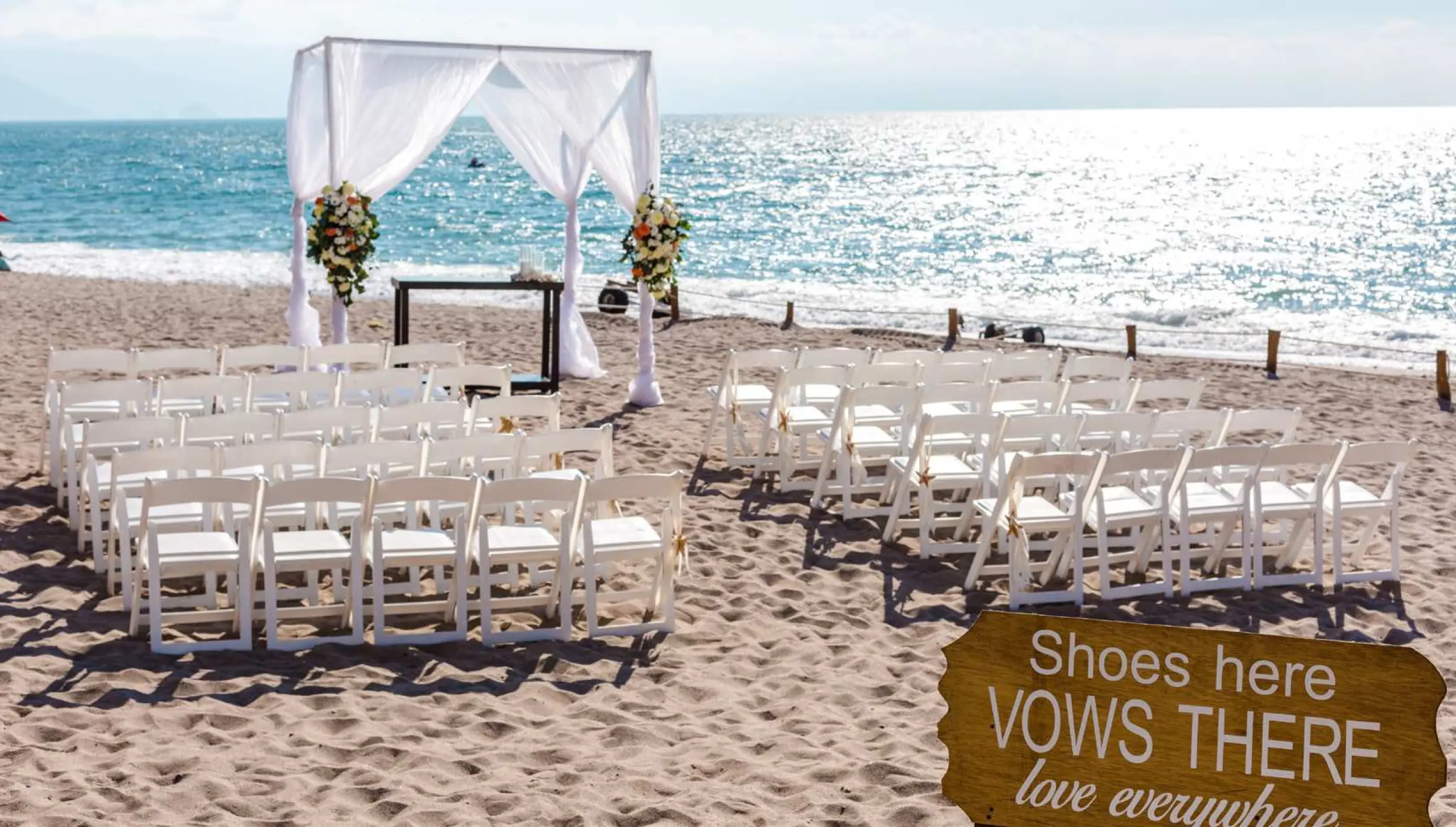 Beachfront wedding ceremony with white gazebo and sign at Secrets Vallarta Bay, Puerto Vallarta