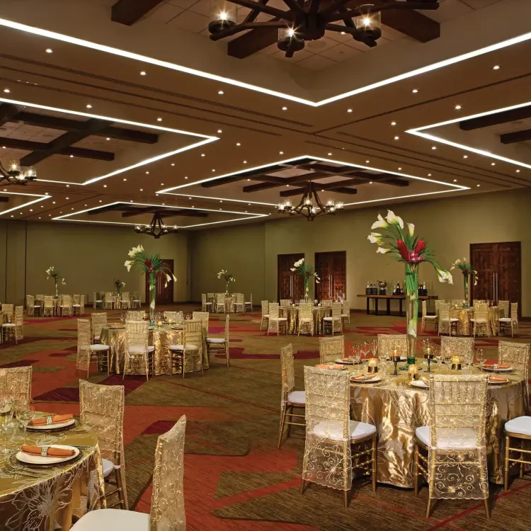 Ballroom wedding reception setup with gold linens at Secrets Akumal, Riviera Maya