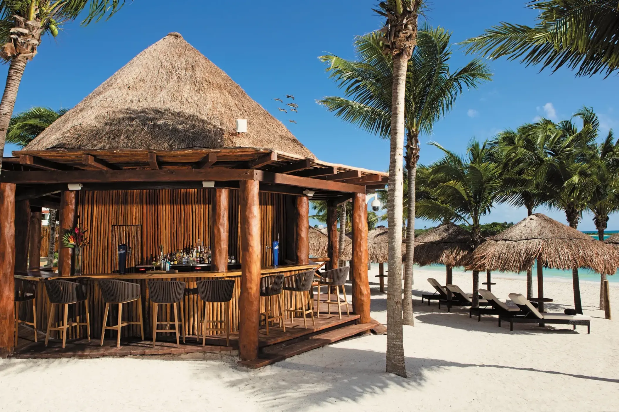 Palapa beach bar and loungers on the sand at Secrets Akumal, Riviera Maya