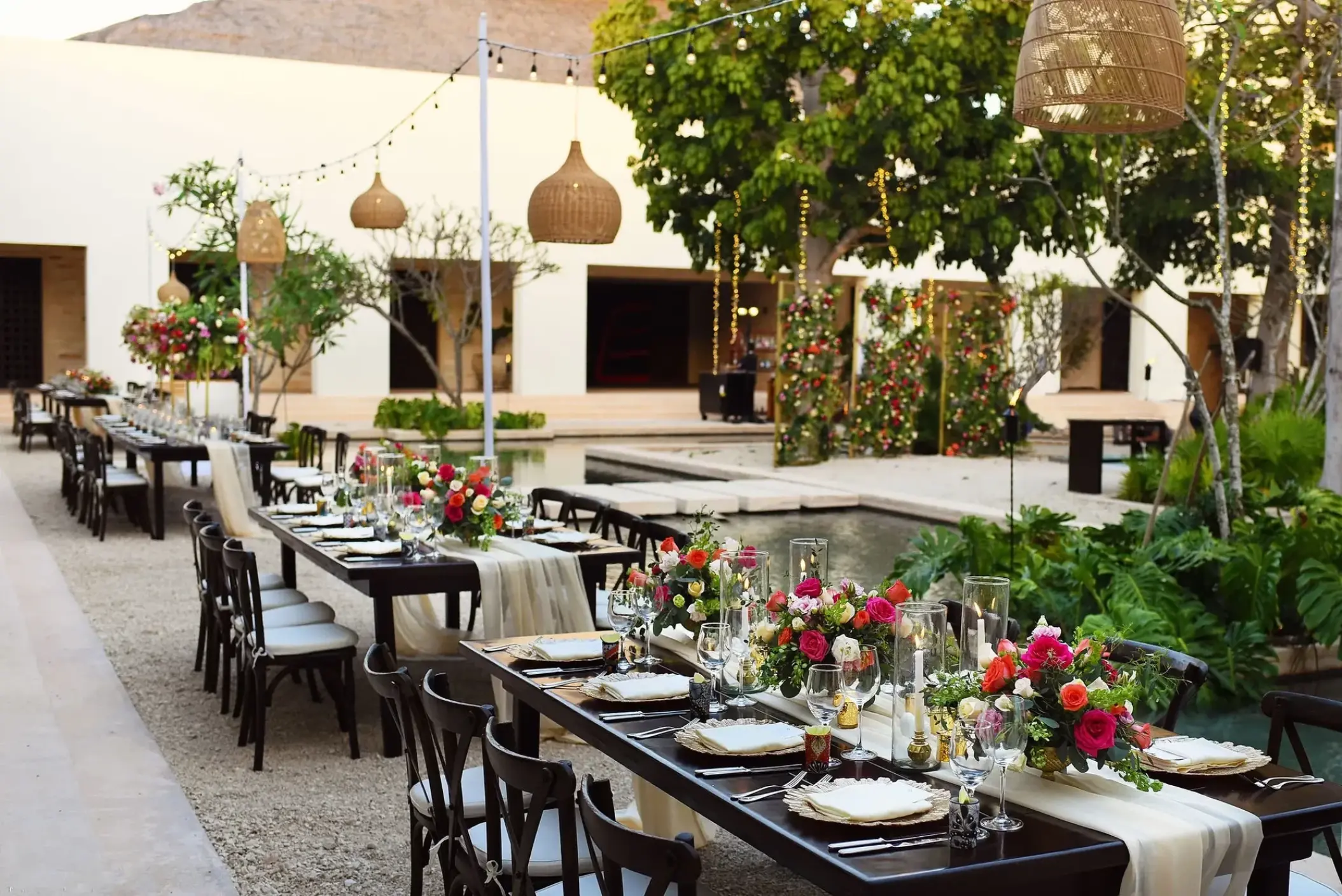 Central Plaza wedding reception with floral centerpieces and hanging lanterns at Secrets Akumal, Riviera Maya