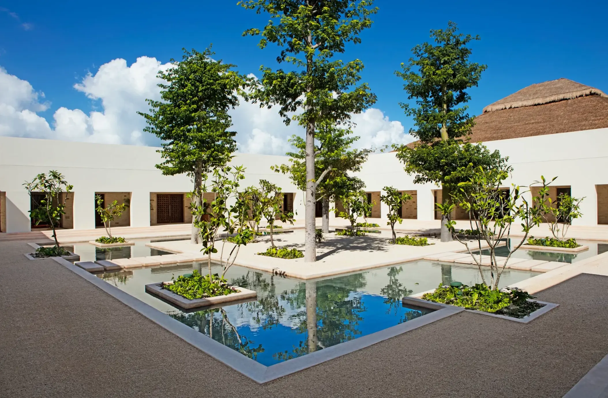 Central plaza with reflecting pools and palm trees at Secrets Akumal, Riviera Maya