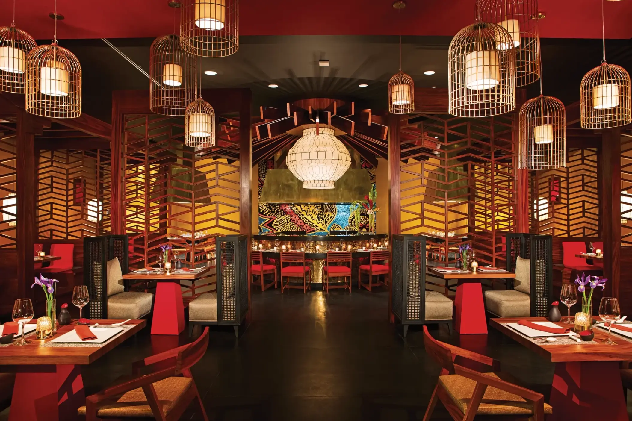Himitsu restaurant interior with red accents and birdcage lanterns at Secrets Akumal, Riviera Maya