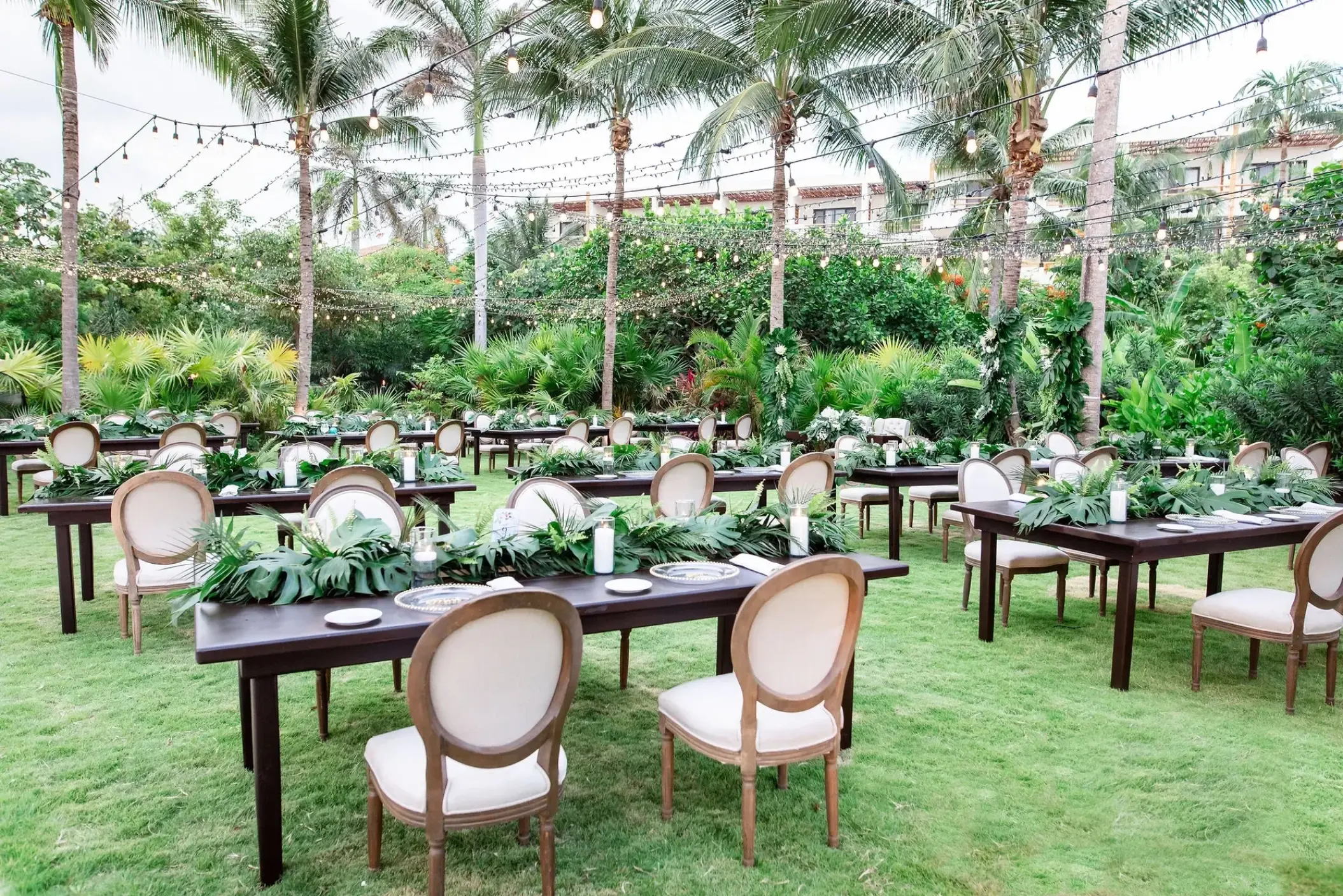 Seaside Garden wedding reception with tropical greenery and string lights at Secrets Akumal, Riviera Maya