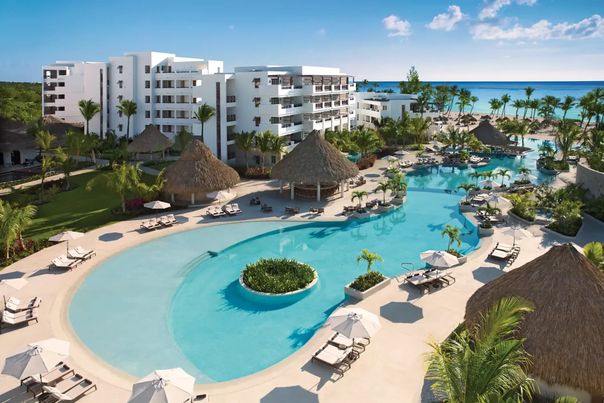 Aerial view of the main swimming pool and thatched palapas at Secrets Cap Cana, Punta Cana