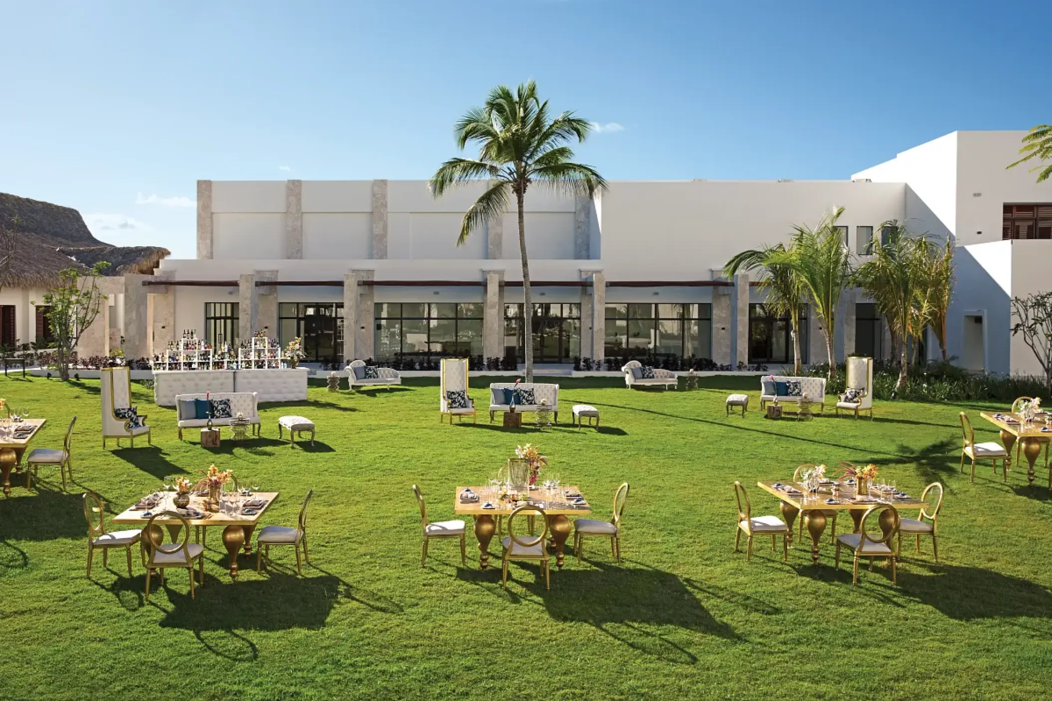 Garden wedding reception with gold tables and white lounge furniture at Secrets Cap Cana, Punta Cana