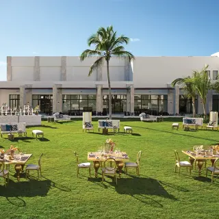 Garden wedding reception with gold tables and white lounge furniture at Secrets Cap Cana, Punta Cana