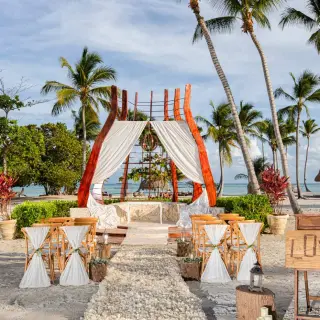 Beachfront wedding ceremony with a modern wood gazebo and white drapery at Secrets Cap Cana, Punta Cana