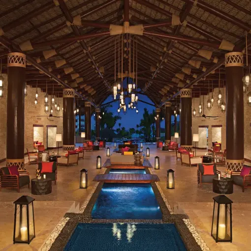 Secrets Cap Cana open-air lobby with water features and lanterns at night, Punta Cana