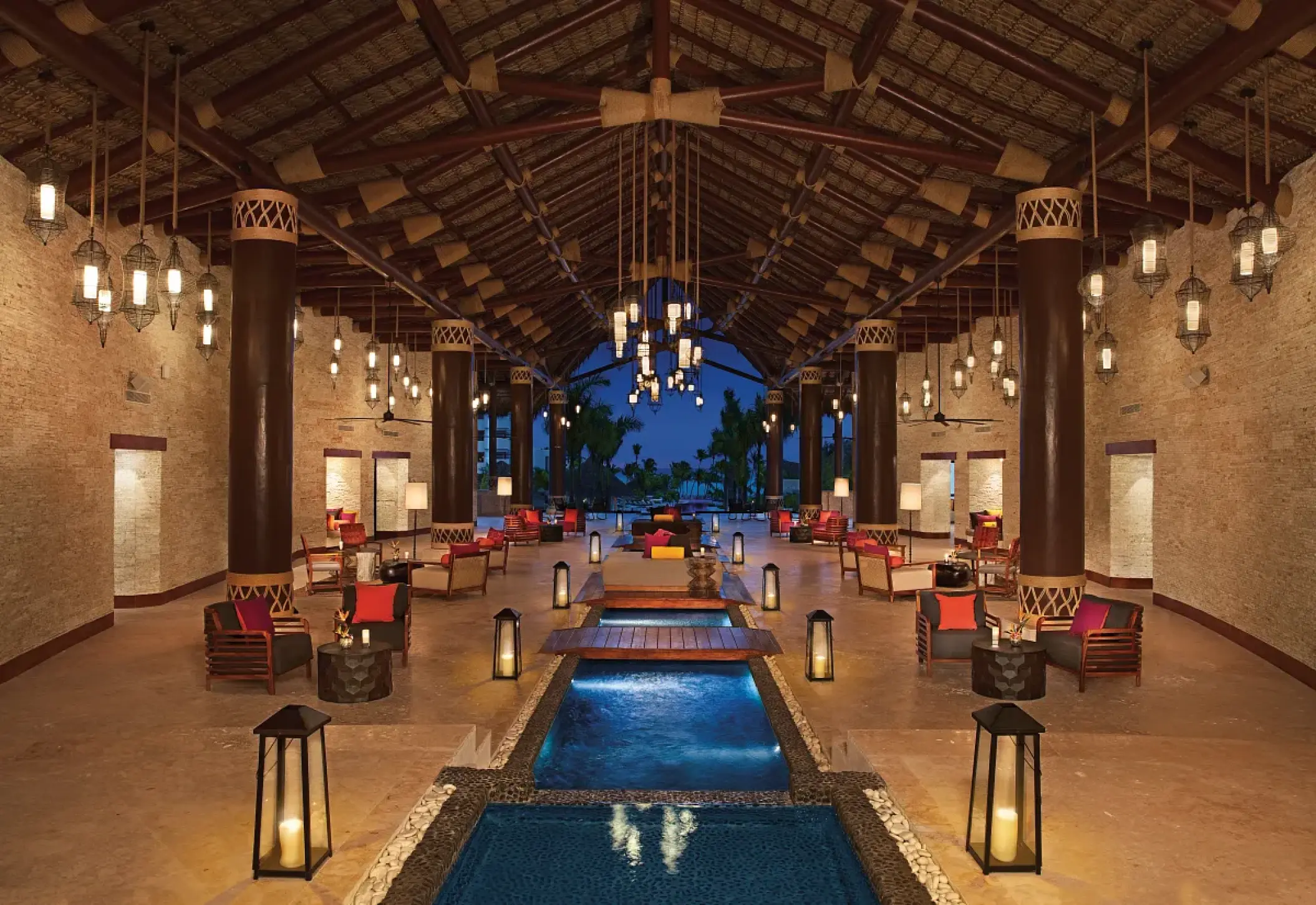 Secrets Cap Cana open-air lobby with water features and lanterns at night, Punta Cana