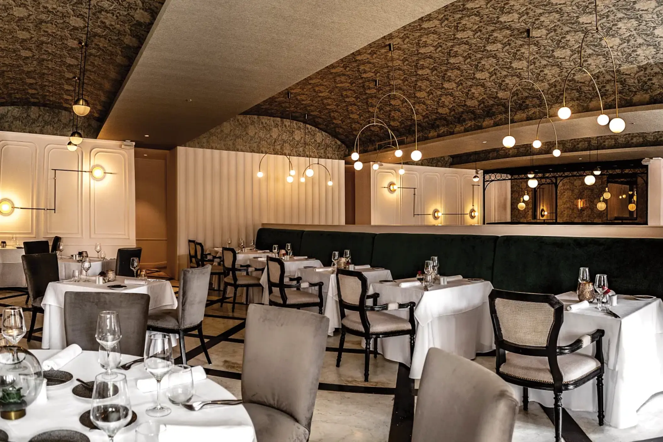 Bordeaux restaurant indoor dining area with arched ceilings and pendant lighting at Secrets Cap Cana, Punta Cana