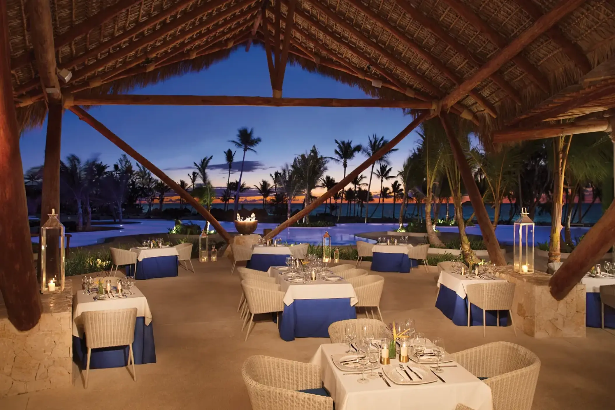 Oceana restaurant tables under a thatched roof at Secrets Cap Cana, Punta Cana