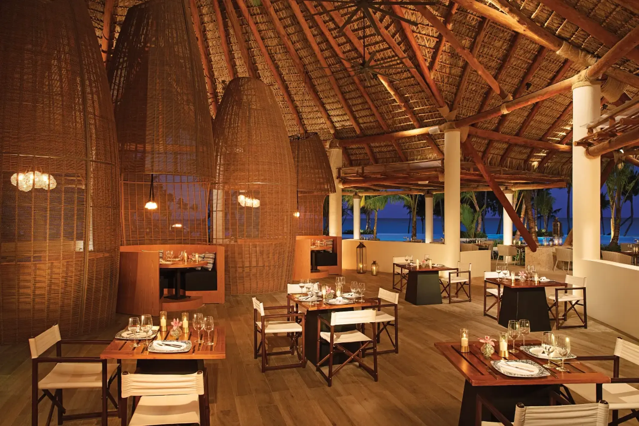 Seaside Grill restaurant with thatched roof and woven light fixtures at Secrets Cap Cana, Punta Cana