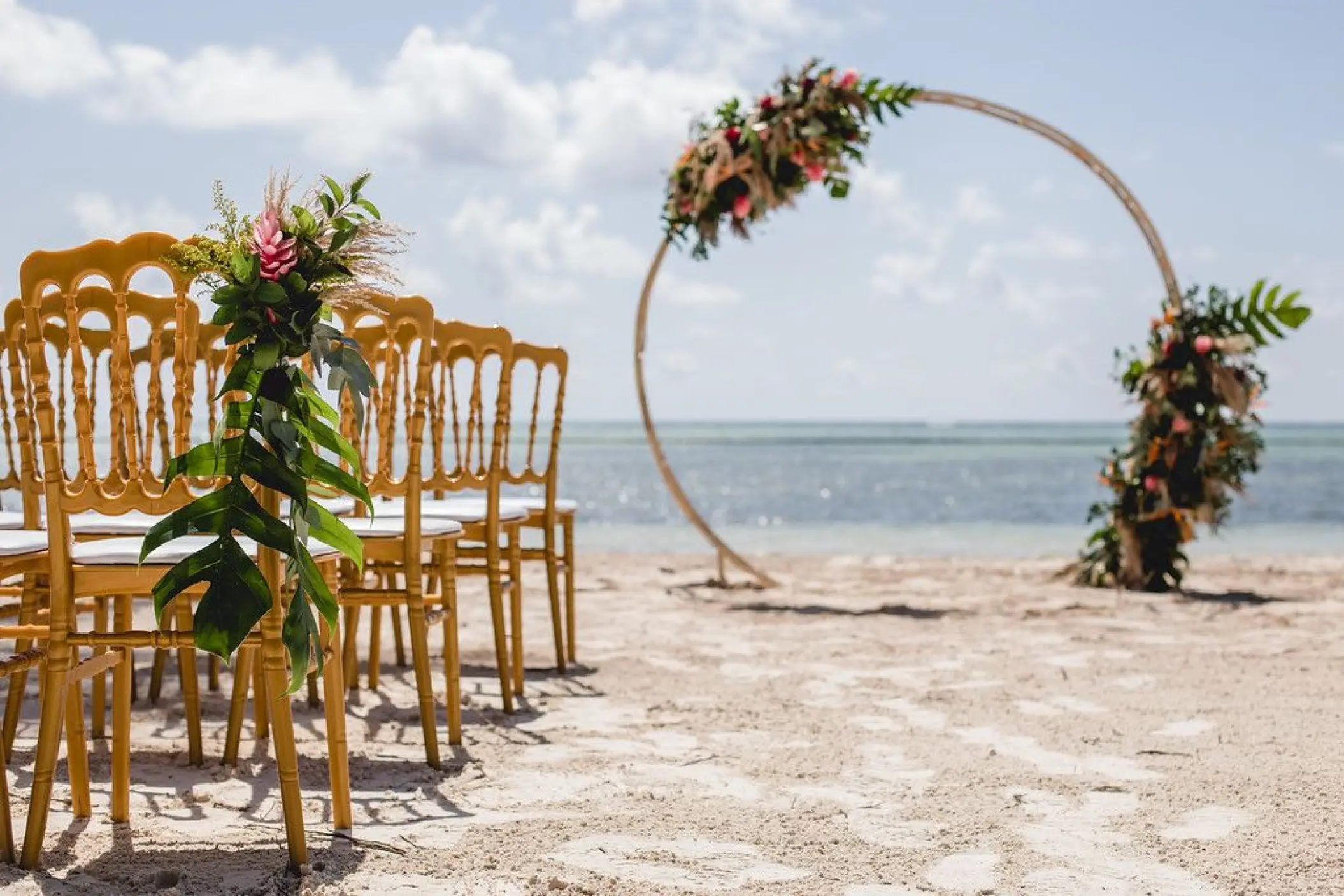 Beachfront wedding ceremony with a floral circular arch at Secrets Cap Cana, Punta Cana