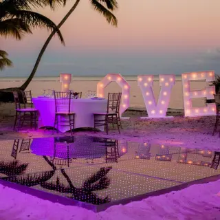 Beachfront wedding reception with lighted LOVE sign and dance floor at Secrets Cap Cana, Punta Cana