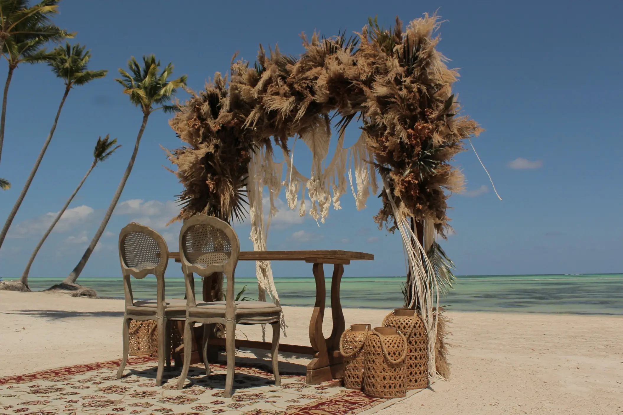 Beachfront wedding ceremony arch with pampas grass and macrame at Secrets Cap Cana, Punta Cana