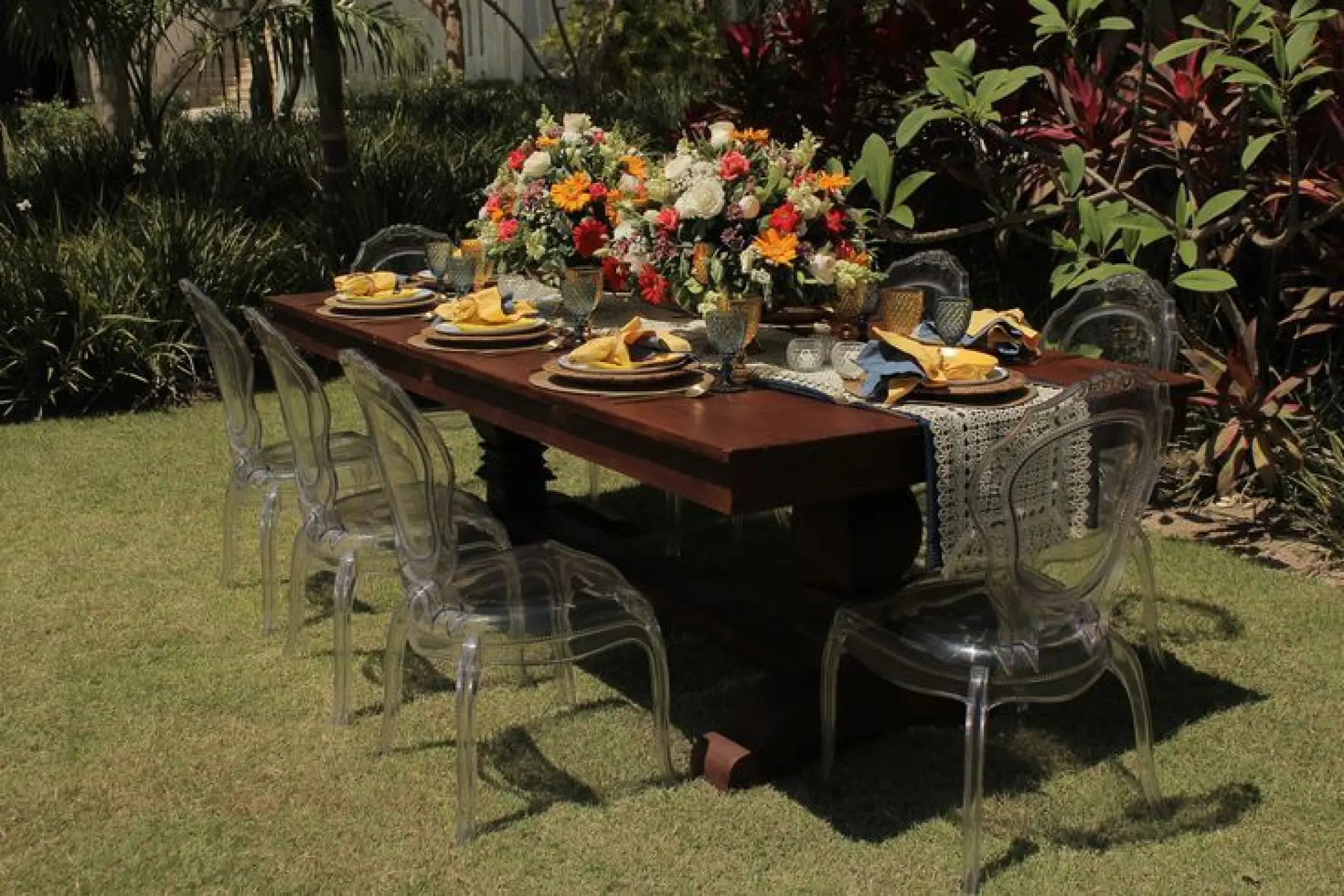 Garden wedding reception table with floral centerpieces and ghost chairs at Secrets Cap Cana, Punta Cana