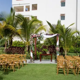 Garden terrace wedding ceremony setup with floral wooden arch at Secrets Cap Cana, Punta Cana