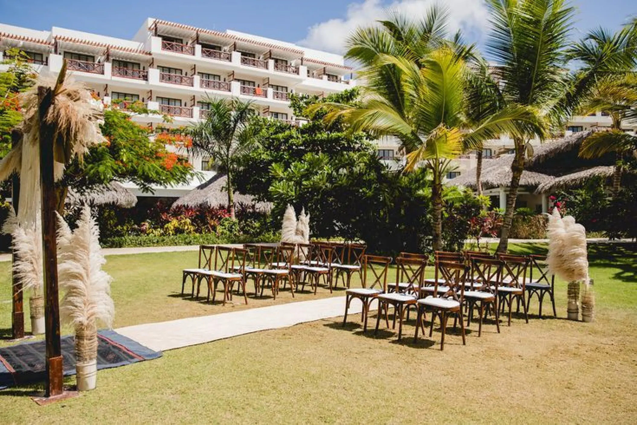 Garden wedding ceremony setup with pampas grass and wooden chairs at Secrets Cap Cana, Punta Cana