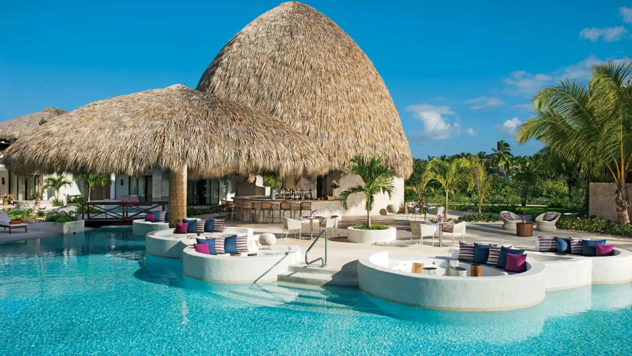 Thatched roof poolside lounge with circular seating at Secrets Cap Cana, Punta Cana