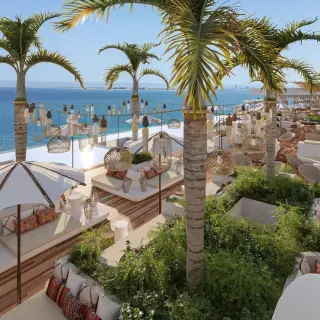 Rooftop lounge with white umbrellas and palm trees at Impression Isla Mujeres by Secrets, Isla Mujeres