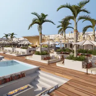 Rooftop lounge with pools, palm trees, and umbrellas at Impression Isla Mujeres by Secrets, Isla Mujeres