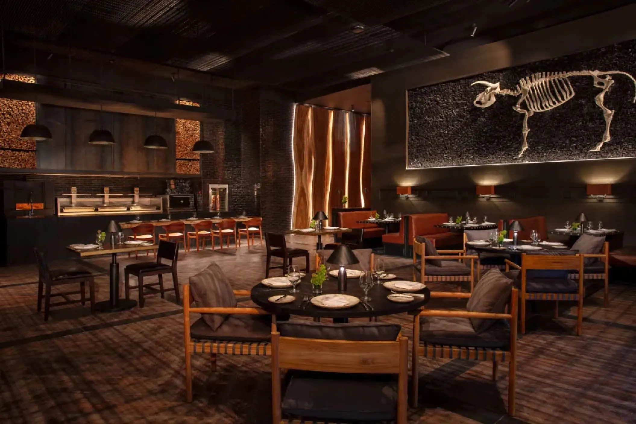 Modern steakhouse dining room with animal skeleton wall art at Secrets Moxche, Playa Del Carmen