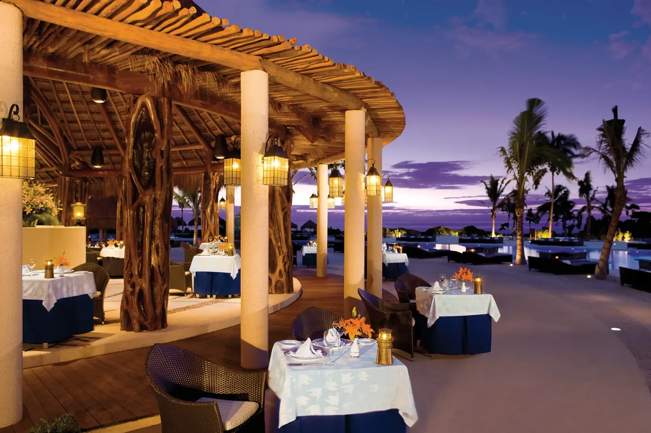 Oceana restaurant with outdoor seating and thatched roof at Secrets Maroma Beach, Riviera Maya