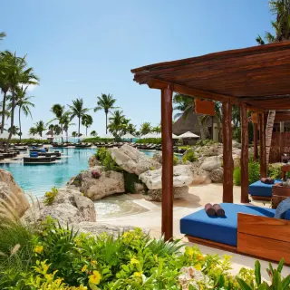 Poolside cabanas next to a large swimming pool at Secrets Maroma Beach, Riviera Maya