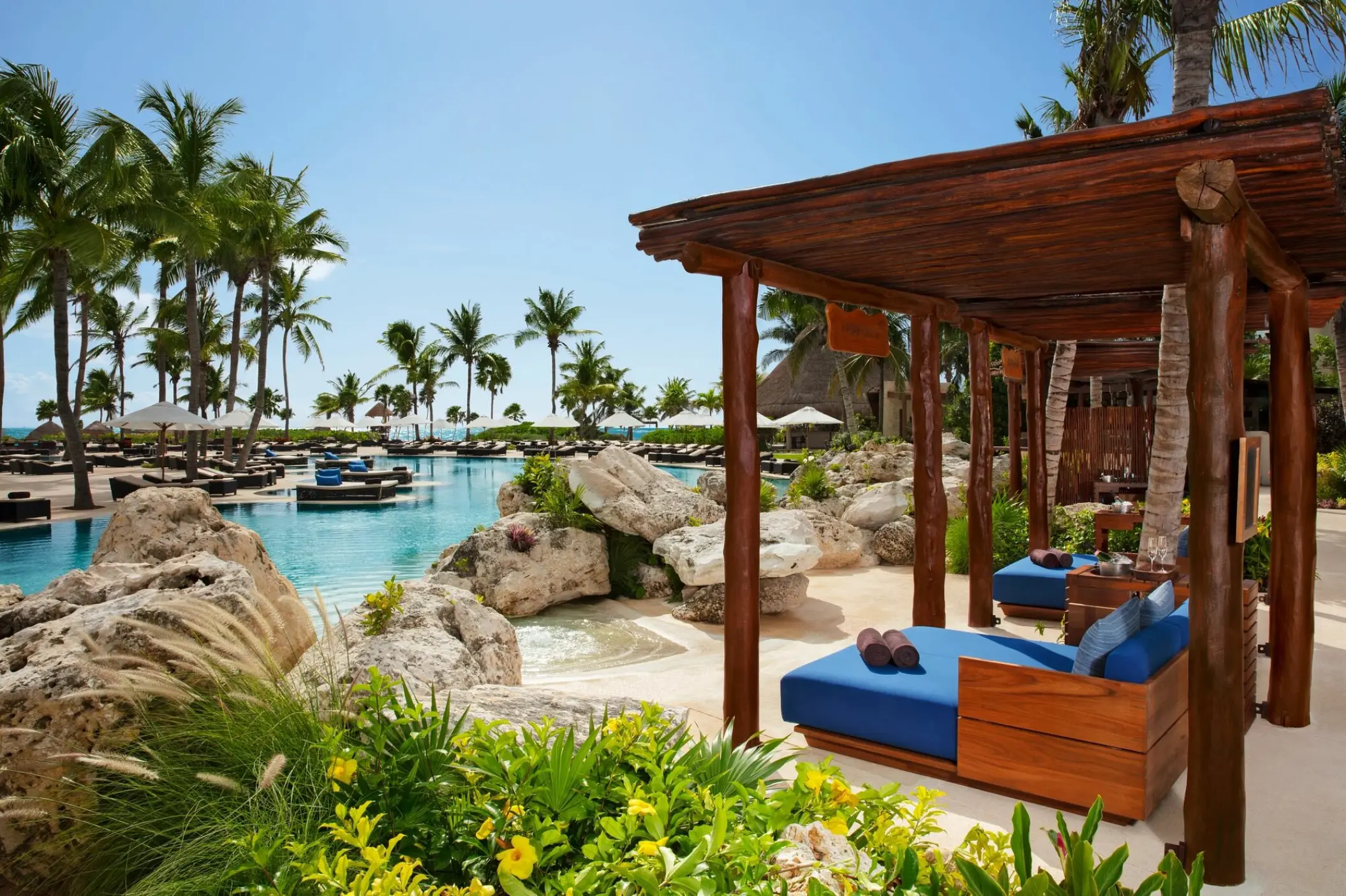 Poolside cabanas next to a large swimming pool at Secrets Maroma Beach, Riviera Maya