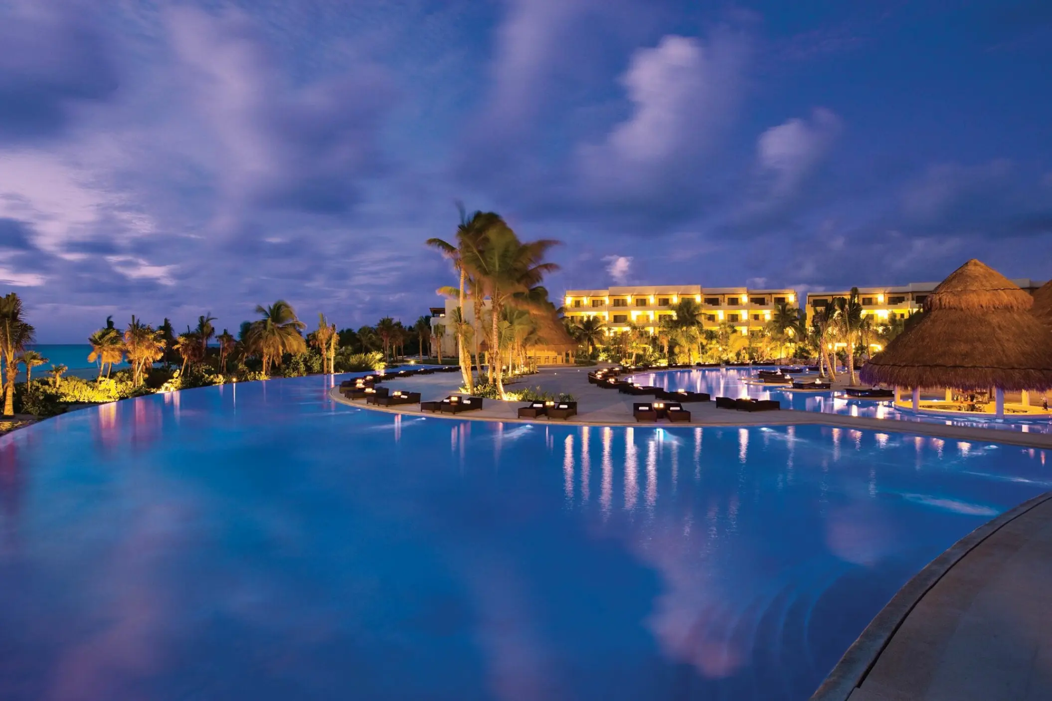 Illuminated infinity pool at night at Secrets Maroma Beach, Riviera Maya