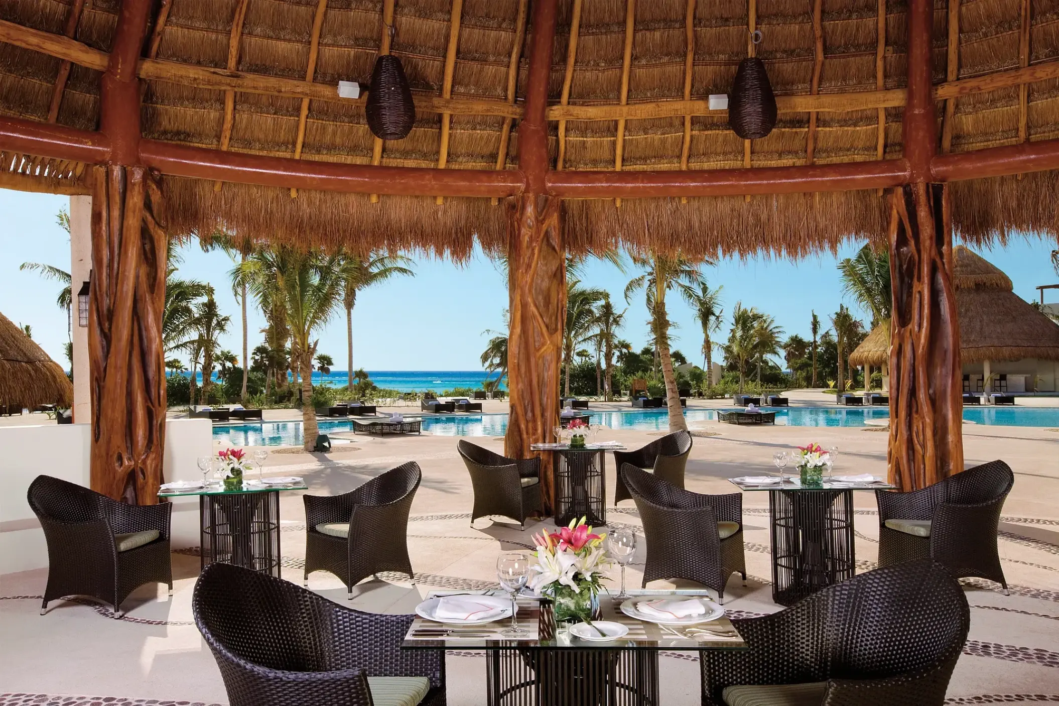 Seaside Grill thatched-roof dining area overlooking the pool at Secrets Maroma Beach, Riviera Maya