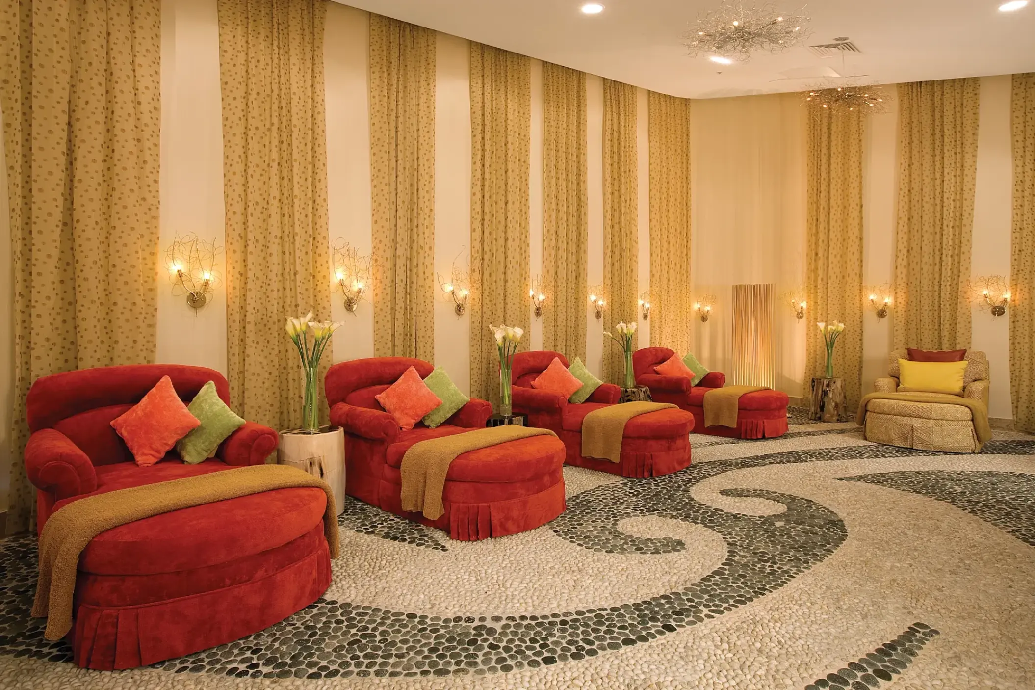 Spa VIP lounge with red velvet chaises and patterned stone floors at Secrets Maroma Beach, Riviera Maya