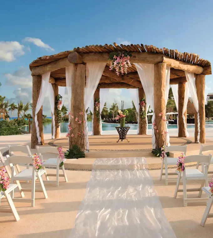 Rustic wooden gazebo wedding ceremony with white chairs at Secrets Maroma Beach, Riviera Maya