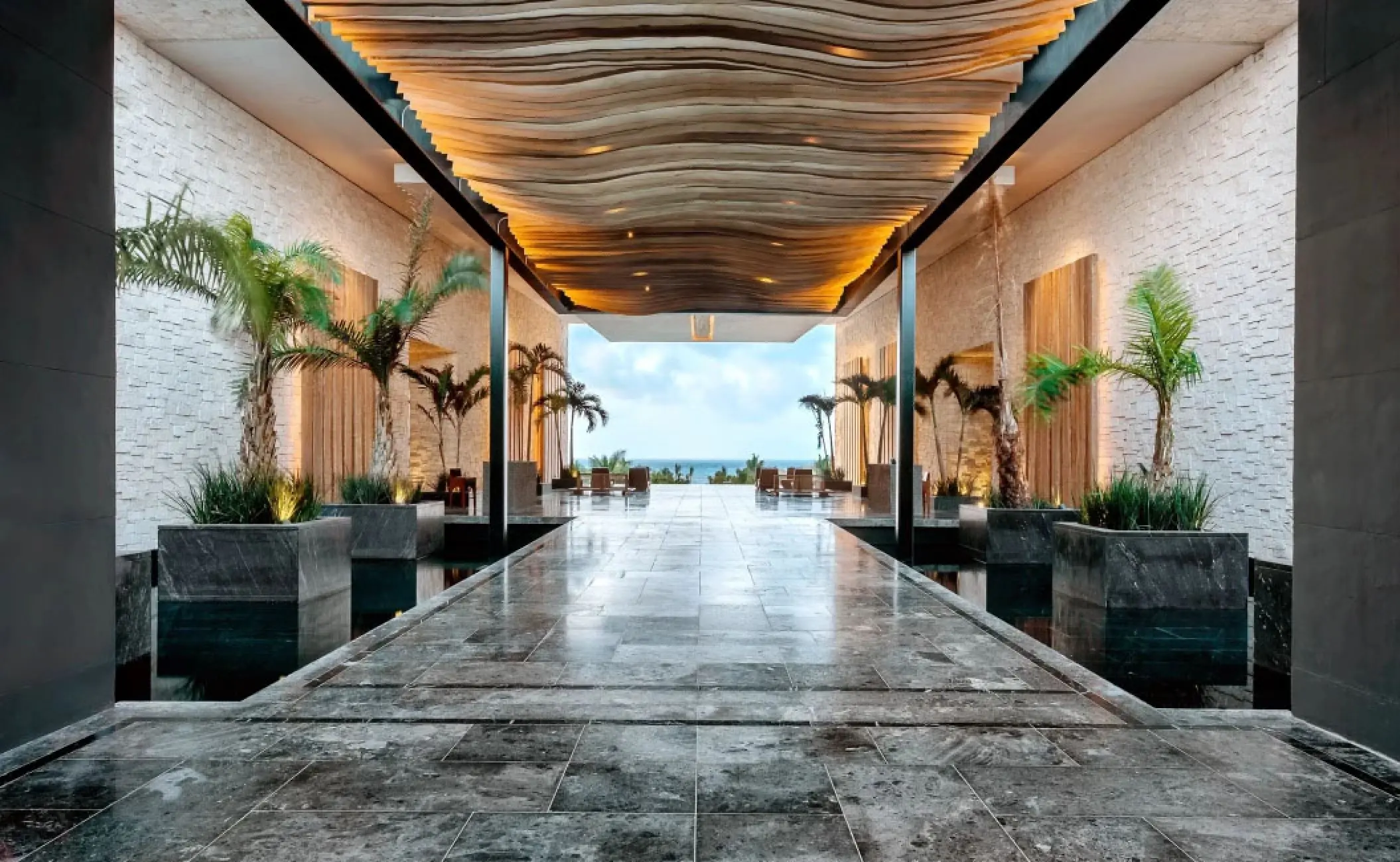 Modern open-air lobby with a wooden wave ceiling at Secrets Moxche, Playa Del Carmen