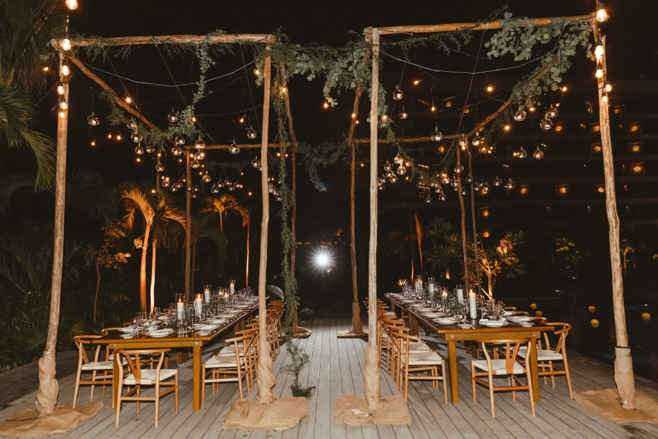 Nighttime wedding reception under a lit wooden canopy at Impression Moxché by Secrets, Playa Del Carmen
