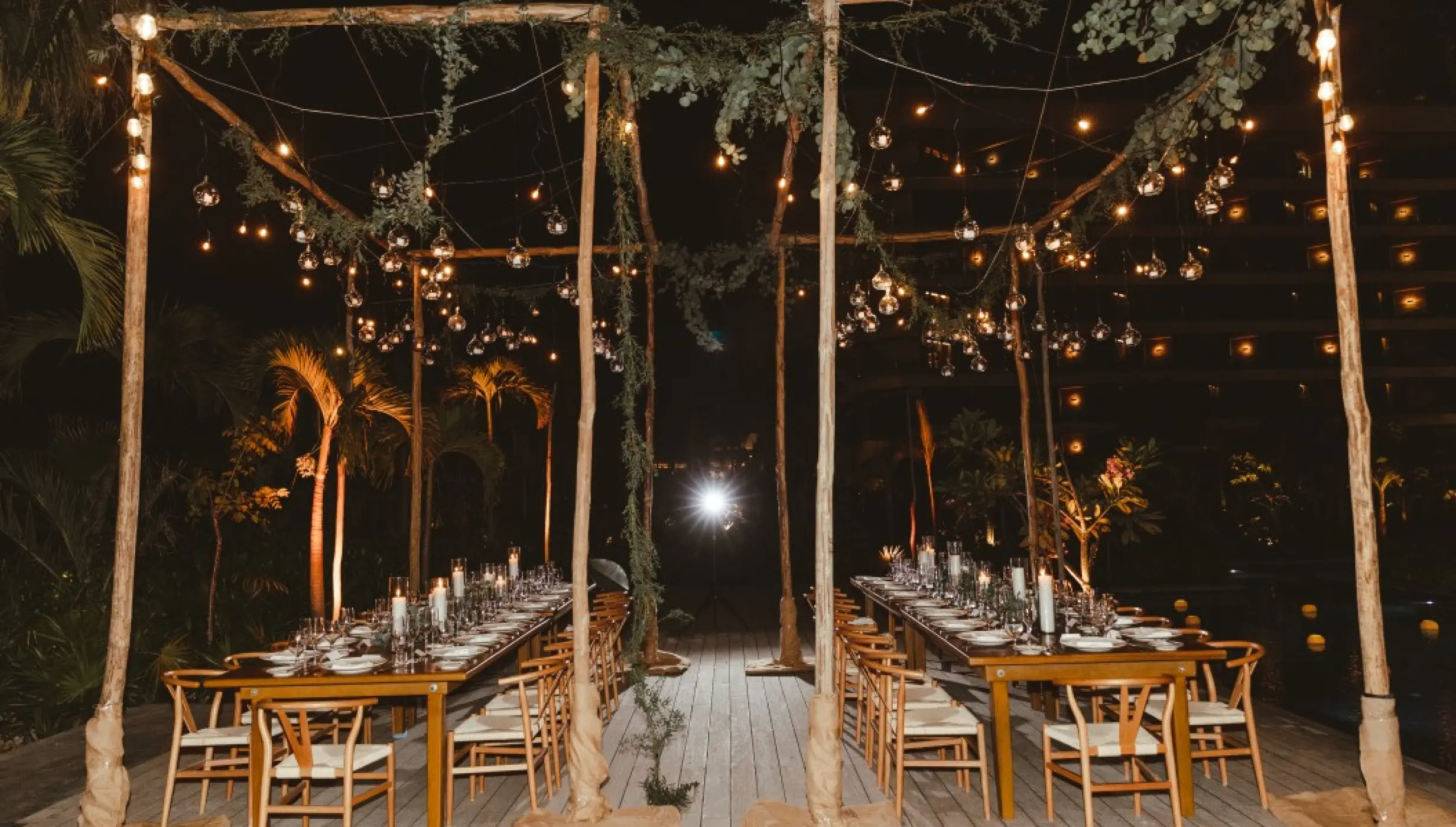 Nighttime wedding reception under a lit wooden canopy at Impression Moxché by Secrets, Playa Del Carmen
