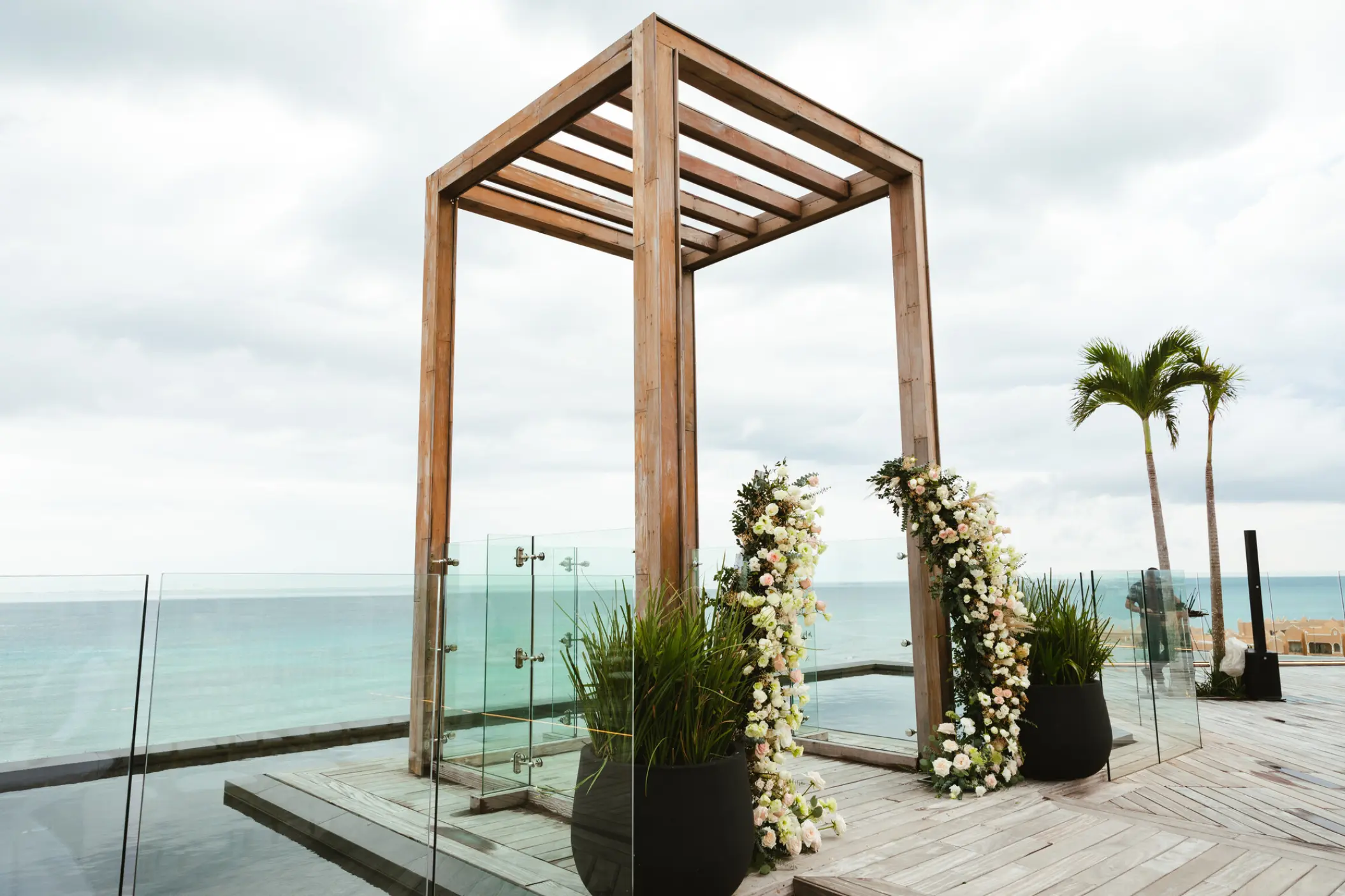 Wooden wedding gazebo with white flowers on a sky terrace at Secrets Moxche, Playa Del Carmen