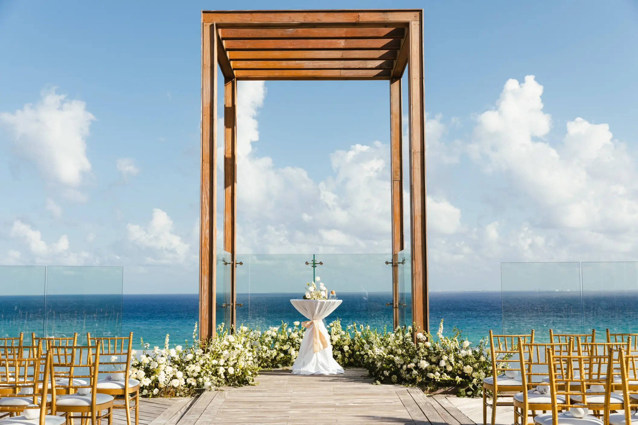 Sky wedding ceremony setup with a wooden gazebo and white flowers at Secrets Moxche, Playa Del Carmen