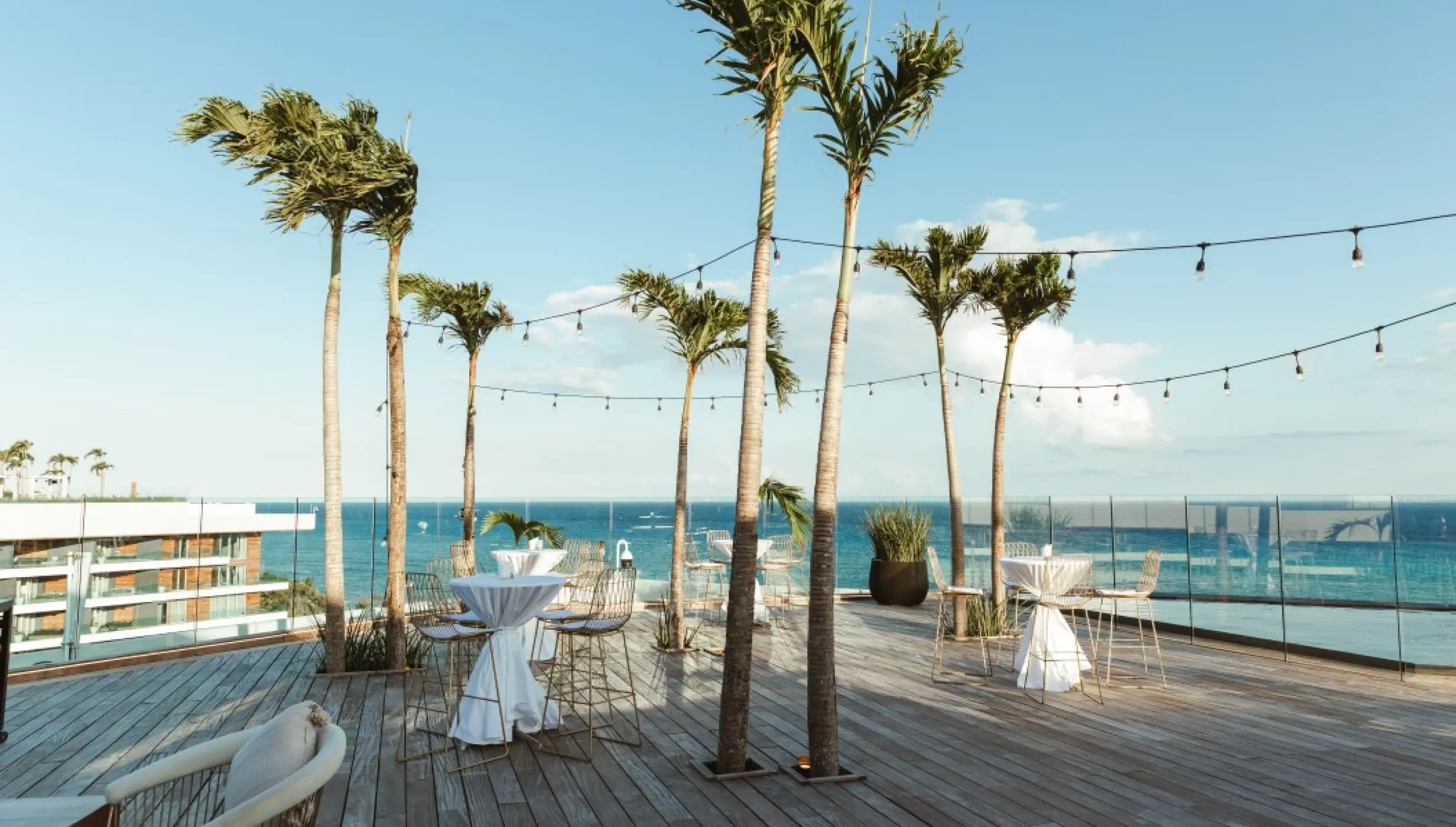 Rooftop cocktail reception setup with palm trees at Impression Moxché by Secrets, Playa Del Carmen