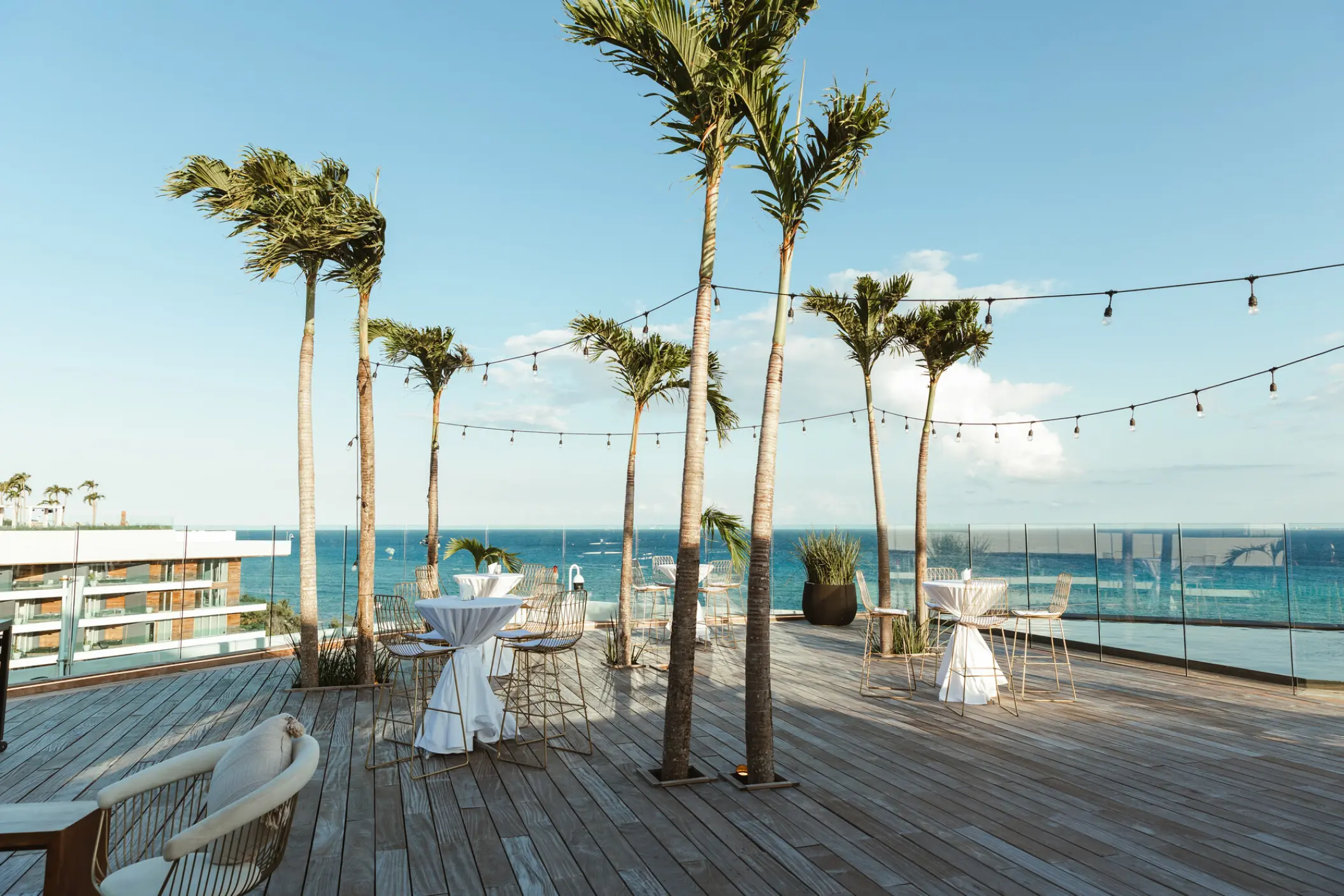 Rooftop wedding reception terrace with palm trees and ocean views at Secrets Moxche, Playa Del Carmen
