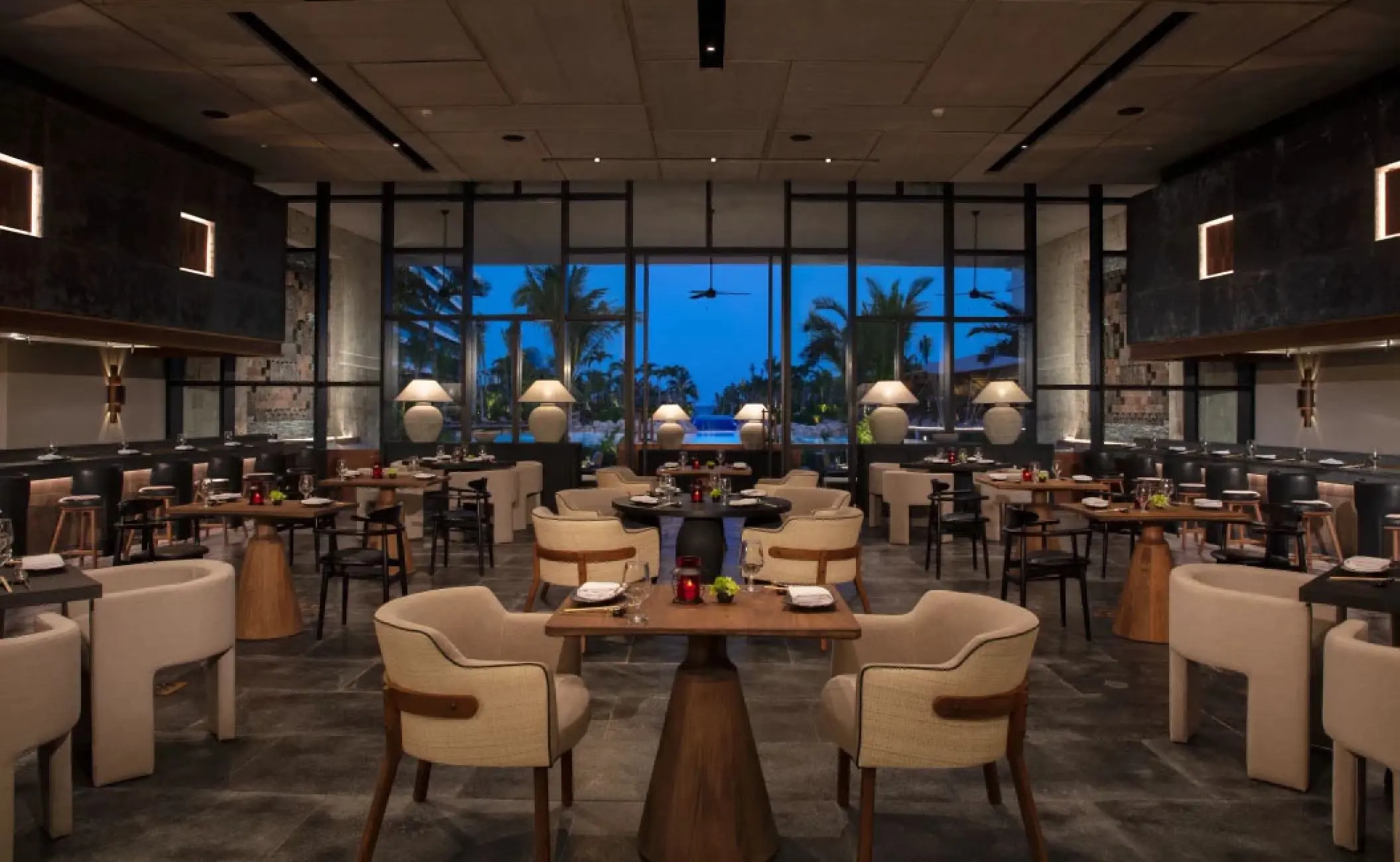 Suki restaurant dining area with modern wooden tables at Secrets Moxche, Playa Del Carmen